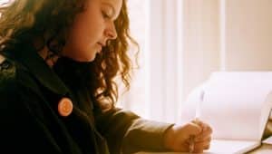 estudante escrevendo sobre as regras dos porquês