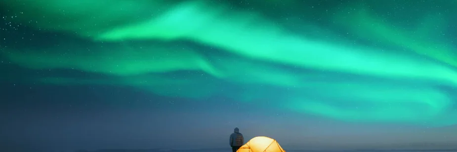 Pessoa com barraca vendo Aurora boreal