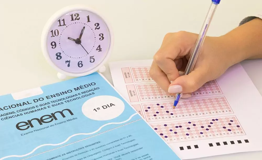 Mulher preenchendo gabarito com relógio ao lado